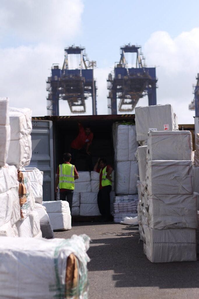 pexels photo 16053939 Dock workers loading cargo at Karachi Port with visible cranes and containers.